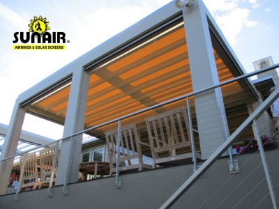 A metal pergola awning over furniture on a patio